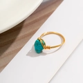 Detail of handmade gold wire-wrapped ring featuring irregular turquoise stone on white display - Style 2 Gold+Blue (0582)