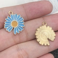 Golden alloy daisy pendant with blue enamel finish shown in detail on a finger - 1Pc Lake Blue Single-Sided Sunflower 18x20mm