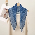 Detail of blue paisley pattern scarf hanging on a wooden hanger with lightweight fabric - Blue