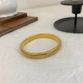 Elegant gold-plated Tubogas spiral bangle with textured finish on white aesthetic background - E44 8mm Striped Bangle Gold