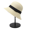 Close-up of beige woven straw bucket hat with elegant black ribbon trim on a stand - M(56-58cm) / Beige