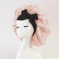 Pink satin sleep bonnet for women featuring a large black bow and elastic wide band - Medium Single Layer Black Cross Ribbon / Coral Pink