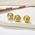 Macro detail of three vintage gold hollow round beads with intricate floral patterns - Style 26