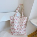 Detalle de bolsa tote de algodón blanco con estampado floral rosa y etiqueta cosida - Flor de Rejilla con Lazo Rosa