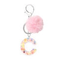 Close-up of resin letter C keychain with colorful sequins and a pink faux fur pom pom - Letter C