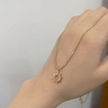 Detailed close-up of a 18K gold sun pendant necklace on a delicate snake chain - Sun