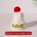 Detailed view of 3.5cm x 5.5cm white knit mini Christmas hat with red pompom and LOVE text - White Hat Letter Red Pom