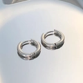 Macro shot of minimalist silver hoop earrings with a mirror-like metallic finish - Basic Silver Round Hoop