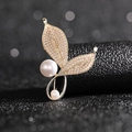 Macro detail of golden leaf brooch featuring small pearls and elegant drop pearl accents - Leaf Brooch