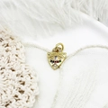Macro van gouden boze oog hanger met gekleurde zirkonia op witte kanten achtergrond - Schild Oog 14,2*10,7mm