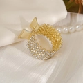 Pince à queue de cheval en alliage doré avec strass blancs et motif d'ailes - Design Ajouré / Or