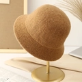 Minimalist warm brown knitted bucket hat for women on a gold display stand - M (56-58cm) / Khaki