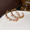 Goldene Creolen mit lila Zirkon-Schmetterlingsanhängern im geometrischen Luxusstil - Goldlilafarbener Schmetterling