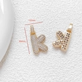 Macro shot of letter K pendant with cubic zirconia and hollow floral back design - Letter K