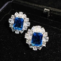 Macro shot of silver halo earrings with blue emerald-cut stone and marquise zirconias - Blue Gemstone Stud Earrings (Pair)