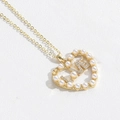 Macro shot of gold heart pendant with LOVE letters and pearls on a fine gold chain - LOVE Heart (5546874938798)