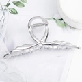 Silver wing-shaped metal hair claw clip with pearl accents on marble surface - Linear Wing Shape Silver B3323