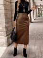 Dettaglio di una gonna midi in pelle PU marrone con pieghe laterali e spacco sulla modella - Taglia S / Pantaloni e gonne / Marrone scuro