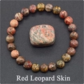 Macro view of natural Red Leopard Skin stone bead bracelet with matching raw specimen - Red Leopard Skin