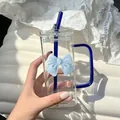 Close-up of square glass cup with blue handle, glass straw and blue 3D bow decoration - Blue Bow Tie + Straw + Transparent Lid