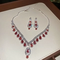 Dettaglio della collana e degli orecchini con rubini rossi su custodia in pelle beige - Argento Rosso