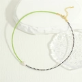 Flat lay of beaded necklace with green beads and a white freshwater pearl pendant - Green And Black (NE2143-E)