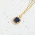 Elegant gold necklace featuring a round dark blue zircon pendant with halo diamonds - Blue