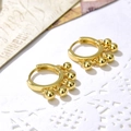 Macro di orecchini a cerchio dorati con sfere di metallo su sfondo di carta vintage - Stile a 5 Perle / Oro