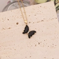 Dettaglio della collana a farfalla dorata con ali nere e micro diamanti su pietra - Nero