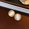 Macro shot of vintage round cat eye stone earrings with a textured gold metal frame - Gold (White Cat's Eye)