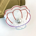 Dettaglio di un fermaglio per capelli a conchiglia in acrilico con perla e bordi colorati - Bianco