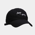 Detailed view of Keep Going embroidery on black cotton baseball cap with adjustable strap - Black