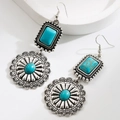 Detail of silver bohemian earrings featuring turquoise stones and floral pattern - Round
