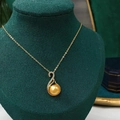 Macro shot of gold swan pendant with freshwater gold pearl on a green velvet stand - 8-9mm (Pendant Only) / Gold