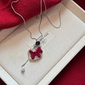 Nahaufnahme der silbernen Halskette mit rotem Samt-Schaukelpferd und weißer Perle - Silberkette-Rotes Schaukelpferd-Stil