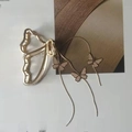 Détail de pince à cheveux papillon dorée avec chaîne à pompons et breloques émail - Pince à Cheveux Papillon Évidé Frange Doré