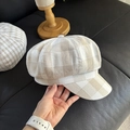Dettaglio del cappello newsboy in lino con trama a quadri beige e cuciture - Coppola (Quadri Larghi)