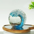 Blue glass paperweight sphere featuring an ocean wave design with gold glitter particles - 80mm Ocean Wave Bubble Ball - Blue Amber