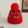 Detail of red knit kids hat with cherry jacquard pattern and large faux fur pom-pom - 1-3 Years / Red