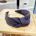 Detailed macro view of dark grey knitted wide knot headband with a handmade inner label - Gray