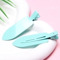 Close-up of two light blue seamless hair clips on a tray for crease-free styling - Tiffany Blue - Glossy without Letters