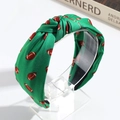 Primer plano detallado de una diadema de tela verde con estampado de fútbol y diseño nudo - Verde Rugby