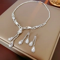 Detailed view of silver pear-cut diamond necklace and earrings set on beige jewelry box - Classic Silver Waterdrop