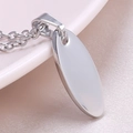 Macro shot of polished silver oval stainless steel pendant with high gloss mirror finish - Necklace (Steel Color)