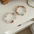 Close-up of natural agate beaded bracelets in red, brown, and green with metallic spacers - Yellow Tower Crystal & Green Aventurine Bracelet