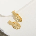 Orecchini placcati oro 14K con texture ondulata irregolare su sfondo in pietra geometrica - Oro
