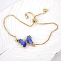 Detailed shot of gold adjustable bracelet with blue crystal butterfly and zircon stones - Dark Blue