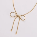 Primer plano de collar dorado con colgante de lazo y elegante detalle de cadena de serpiente - Dorado