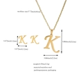 Vista dettagliata della collana e orecchini 'K' in acciaio dorato con dimensioni precise - Lettera K / Oro
