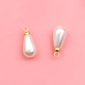Pair of teardrop pearl pendants with gold metal loops for DIY jewelry on pink backdrop - 6x10mm KC Gold Water Drop